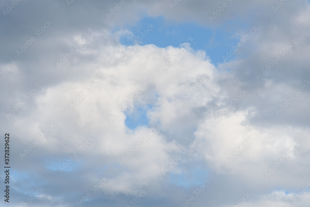 Fluffy white clouds against a blue sky as a nature background
