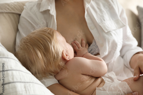 Mother breastfeeding her little baby at home. Healthy growth