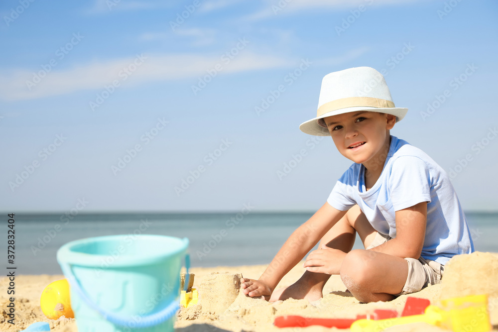 Cute little boy playing with plastic toys on sandy beach Cute little boy playing with plastic toys on sandy beach
