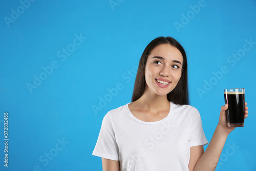 Beautiful woman with cold kvass on blue background. Traditional Russian summer drink © New Africa