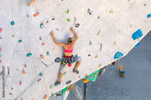 A woman is climbing a climbing wall