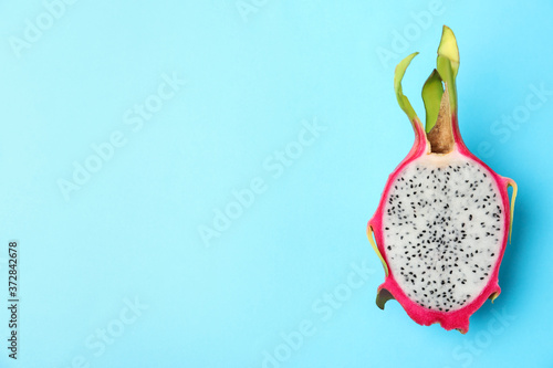 Half of delicious ripe dragon fruit (pitahaya) on light blue background, top view. Space for text