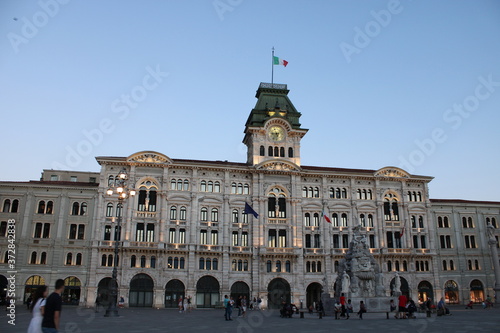 City hall of Trieste with people walking.