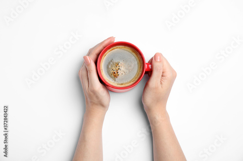 Woman with cup of coffee on white background, top view