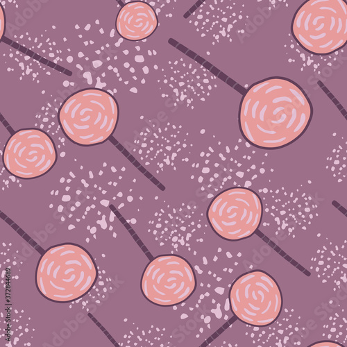 Random candy ornament silhouettes seamless pattern. Purple background with splashes. Pink lollipops.