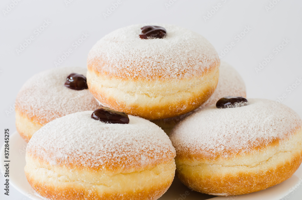Traditional sweet donuts with powdered sugar and jam. Fat Thursday or Hanukkah celebration.