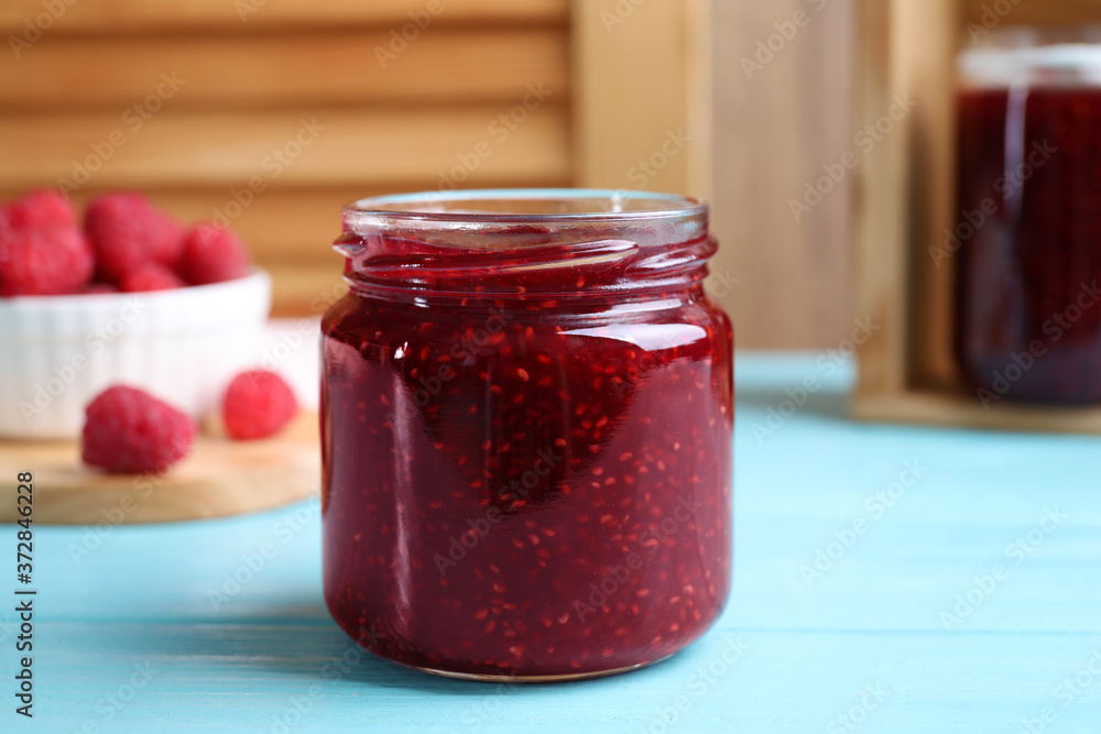 Delicious raspberry jam on light blue wooden table, closeup Delicious raspberry jam on light blue wooden table, closeup