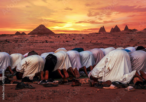 KARIMA, SUDAN - May 29, 2019: Muslims praying in Sudan sunset photo