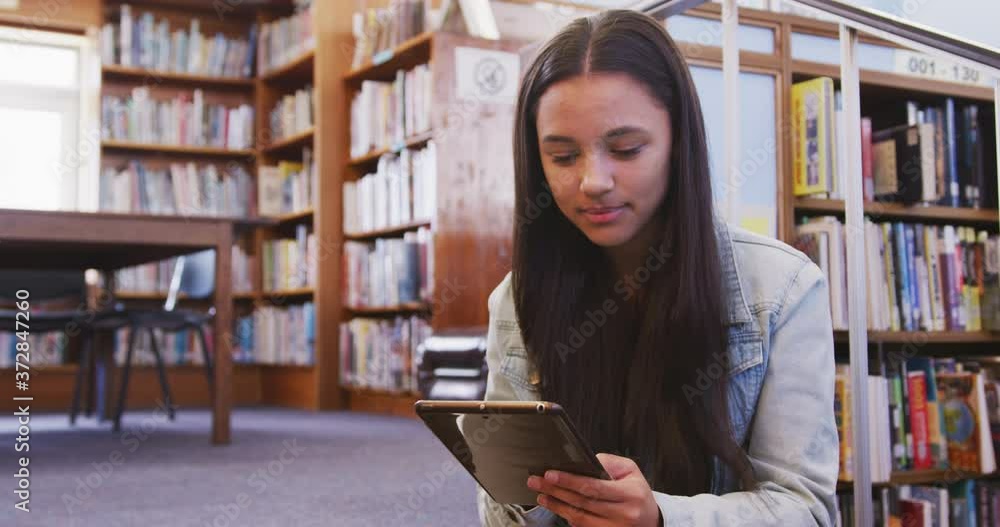 Asian female student sitting and using a tablet Asian female student sitting and using a tablet