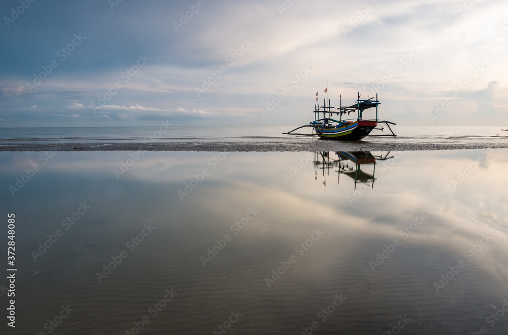 traditional fishing boat leaning on the beach in the morning tuban east java