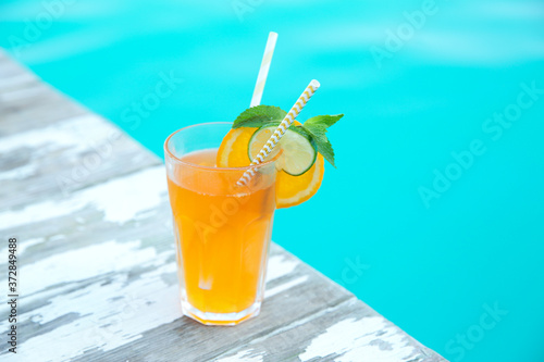 Refreshing cocktail near outdoor swimming pool on sunny day