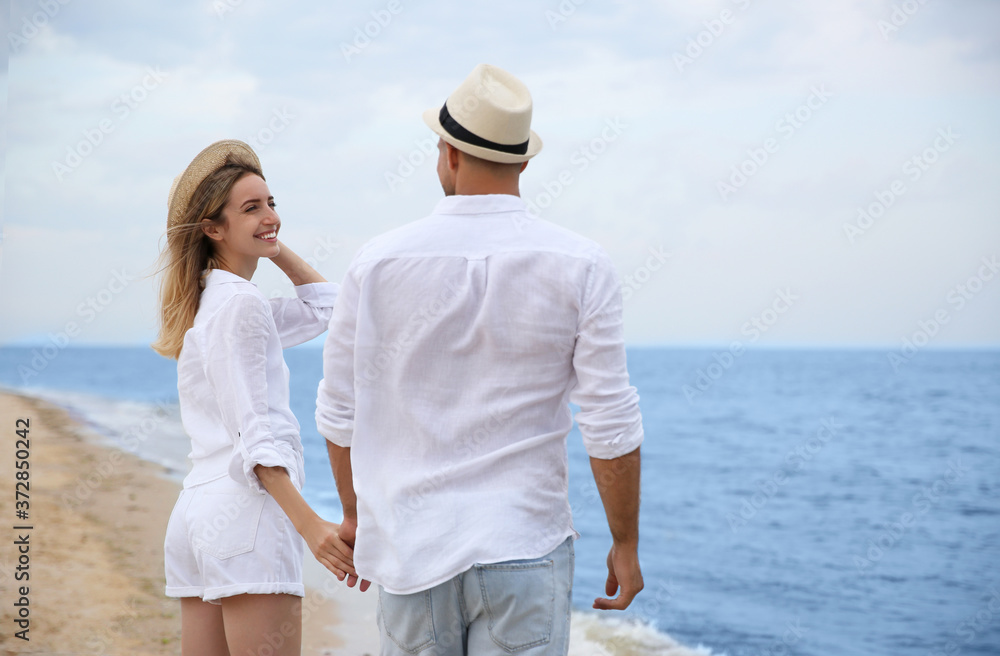 Happy couple having romantic walk on beach Happy couple having romantic walk on beach