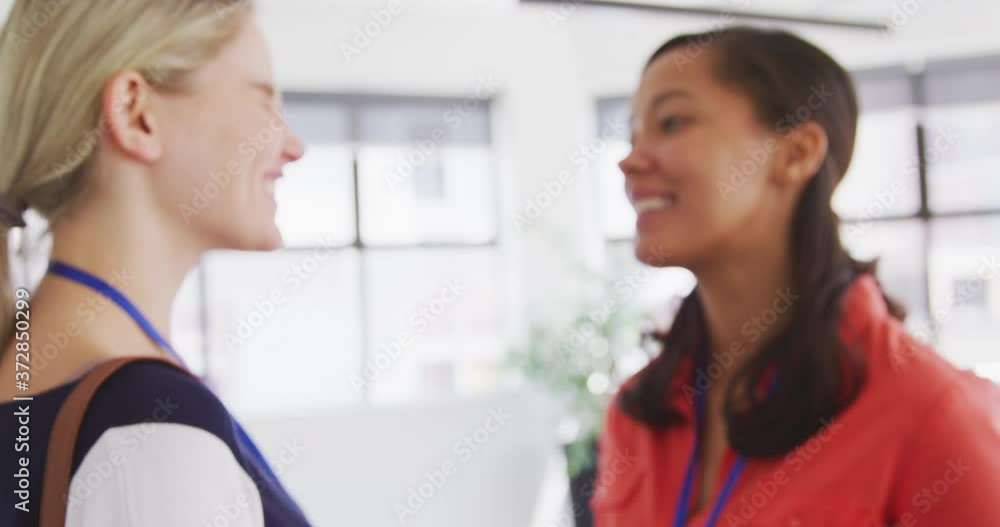 Businesswomen talking while businessmen shaking hands Businesswomen talking while businessmen shaking hands