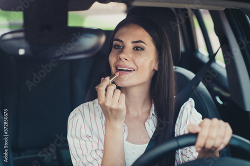 Close-up portrait of her she nice attractive lovely pretty successful glamorous girl worker riding car making visage applying nude lip balm wellness wellbeing traffic jam free time