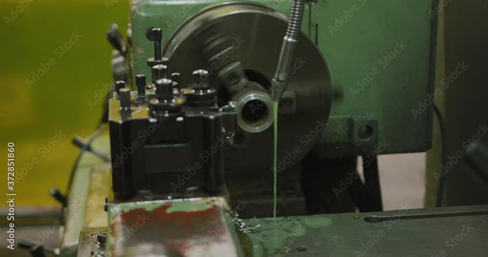 Piece of machinery in the workshop at a factory turning and cutting a piece of metal pipe Piece of machinery in the workshop at a factory turning and cutting a piece of metal pipe