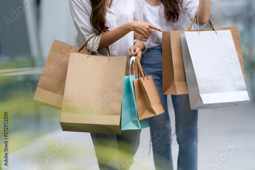 Happy friends shopping, Two young female are holding shopping bags photo