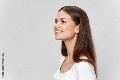 Beautiful brunette woman smiling on isolated background white t-shirt cropped view