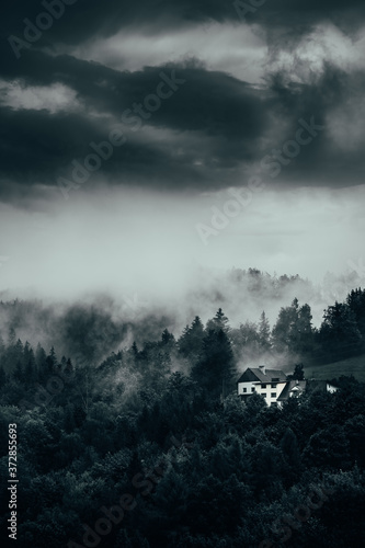 Fototapeta Naklejka Na Ścianę i Meble -  Misty mountain landscape with white house