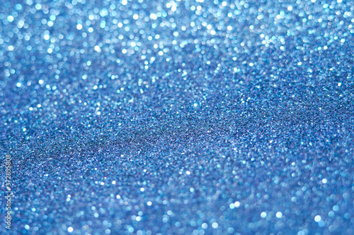 blue Sparkling Lights Festive background with texture. Abstract Christmas twinkled bright bokeh defocused and Falling stars. Winter Card or invitation 