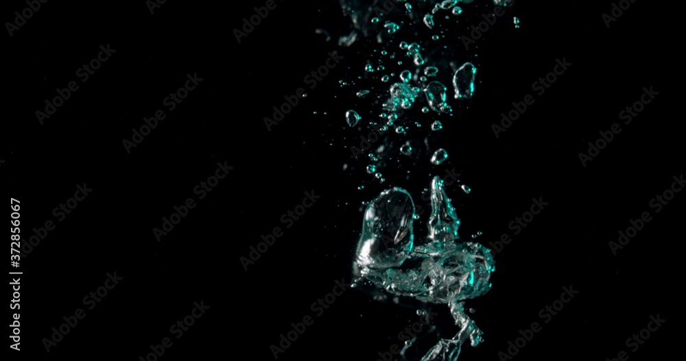 blue and green bubbles splashing down into the dark water. blue and green bubbles splashing down into the dark water.