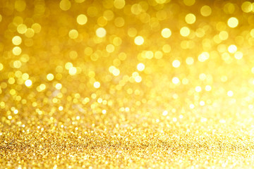 gold Sparkling Lights Festive background with texture. Abstract Christmas twinkled bright bokeh defocused and Falling stars. Winter Card or invitation	