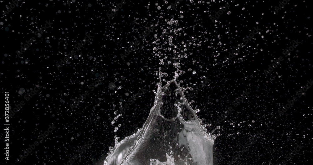water rising up from the center of a black background. water rising up from the center of a black background.