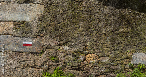 Closeup of indication hiking in an old stone wall on the way to Santiago