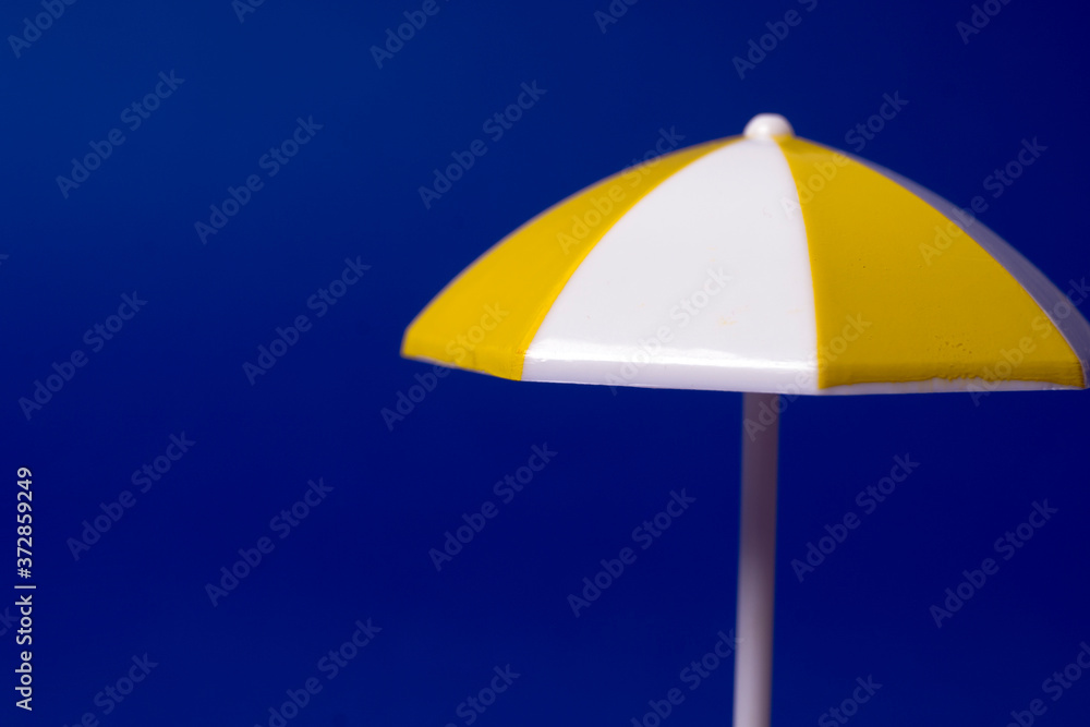 multicolored beach umbrella on blue background multicolored beach umbrella on blue background