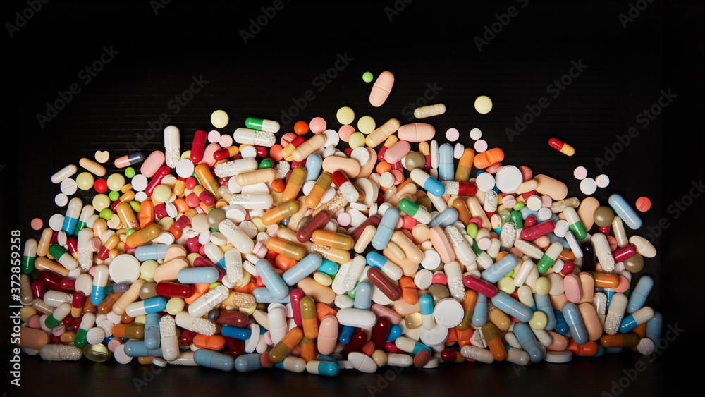 Fototapeta premium Viele bunte Medikamente auf dunklem Hintergrund