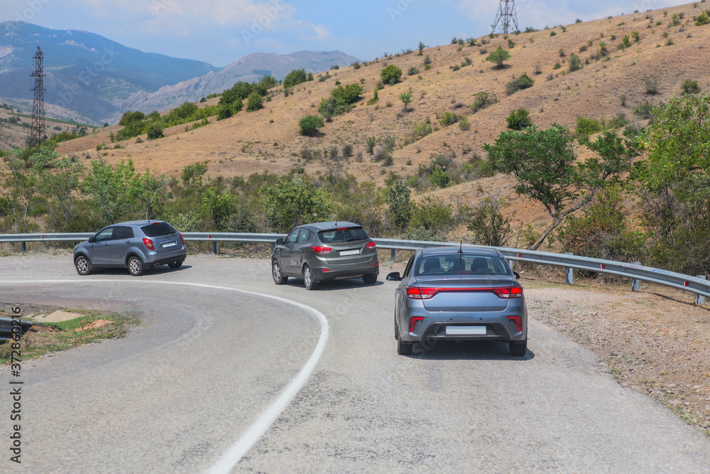 Cars move along a winding mountain road
