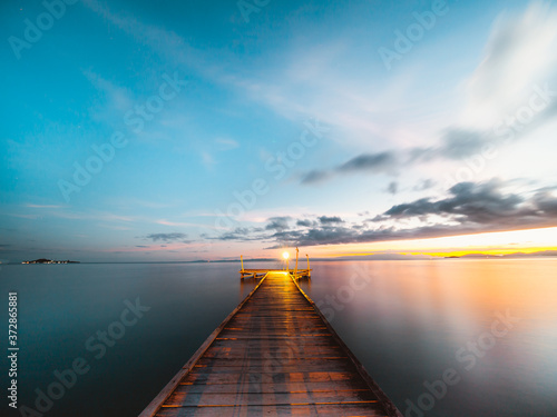Wooden jetty at sunset over the ocean, long exposure