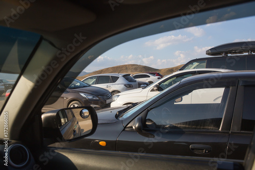 View from the car to parked cars in a hilly area © Yuri Bizgaimer