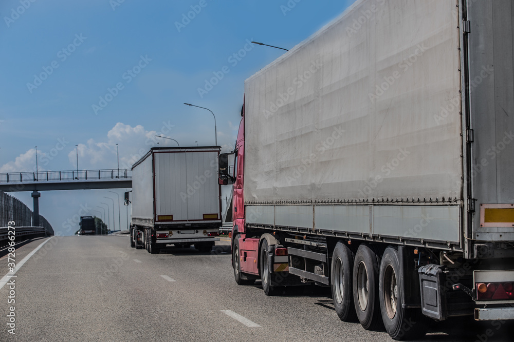 Trucks deliver cargo in opposite directions on a suburban highway Stock ...