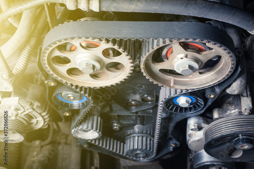 new timing belt with rollers installed on the old engine in a car workshop. Close up
