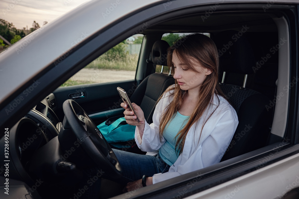 a beautiful young woman driving a grey car. a beautiful young woman driving a grey car.