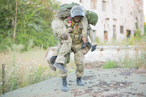 Φωτογραφία Military partner carries his wounded partner from shelling