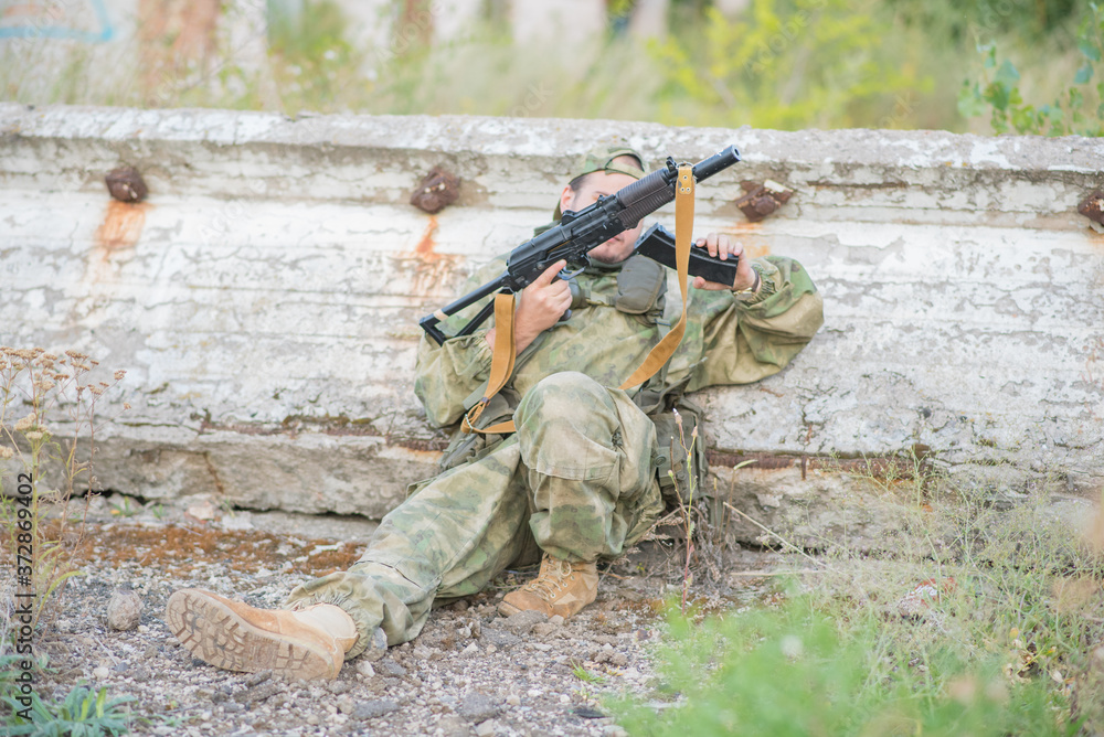 Fototapeta premium Airsoft player reloads his weapon during a firefight