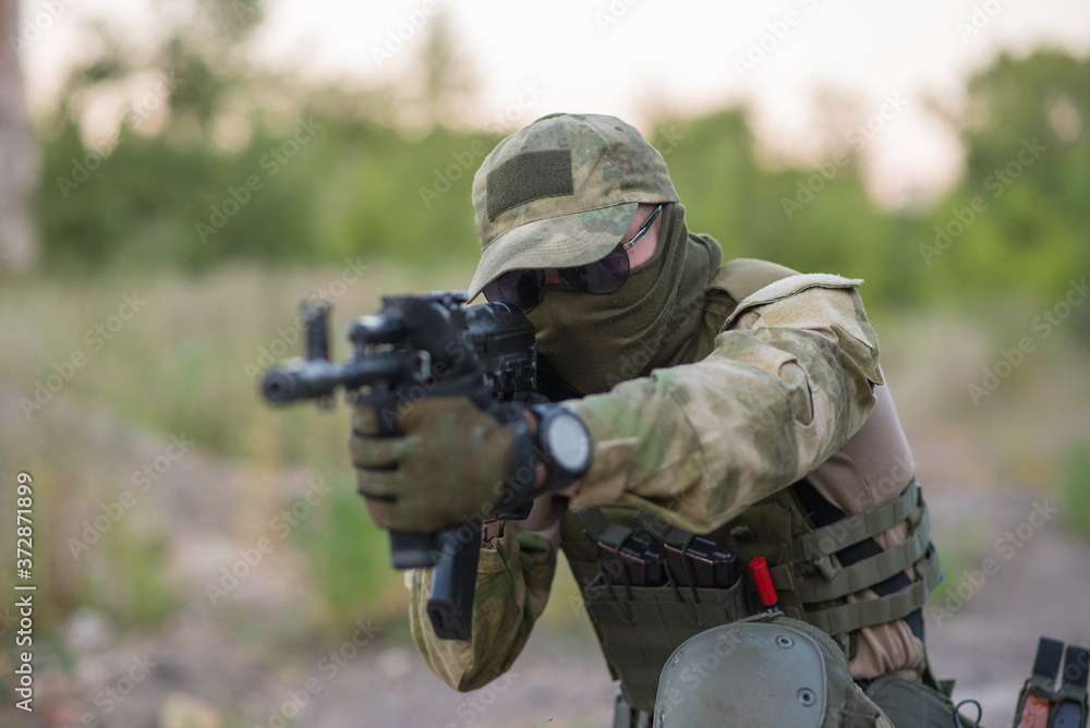 Fototapeta premium A professional airsoft player aims at his opponents
