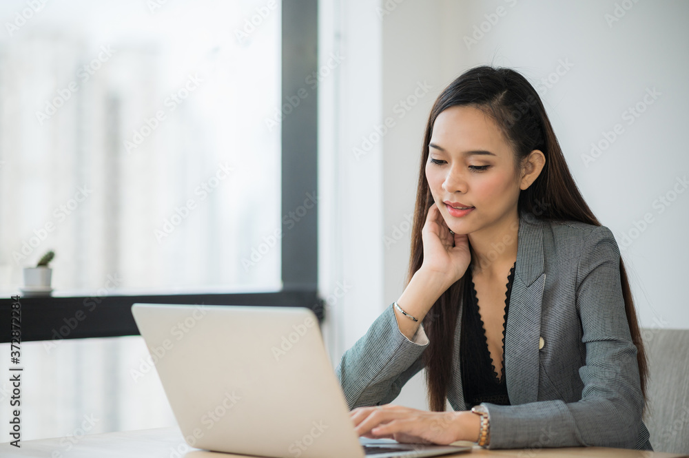 Beautiful asian businesswoman using laptop working in office and smiling. Beautiful asian businesswoman using laptop working in office and smiling.