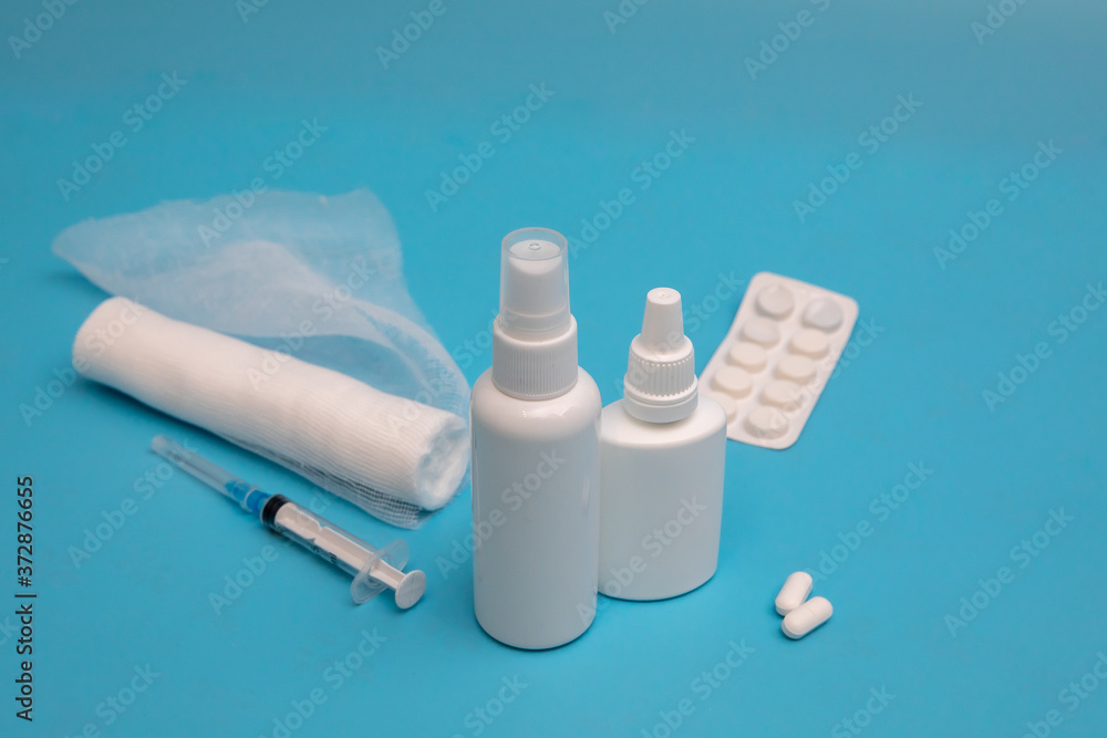 Nasal spray, pills, syringe, bandage injection on a blue background. Medicine concept. Nasal spray, pills, syringe, bandage injection on a blue background. Medicine concept.