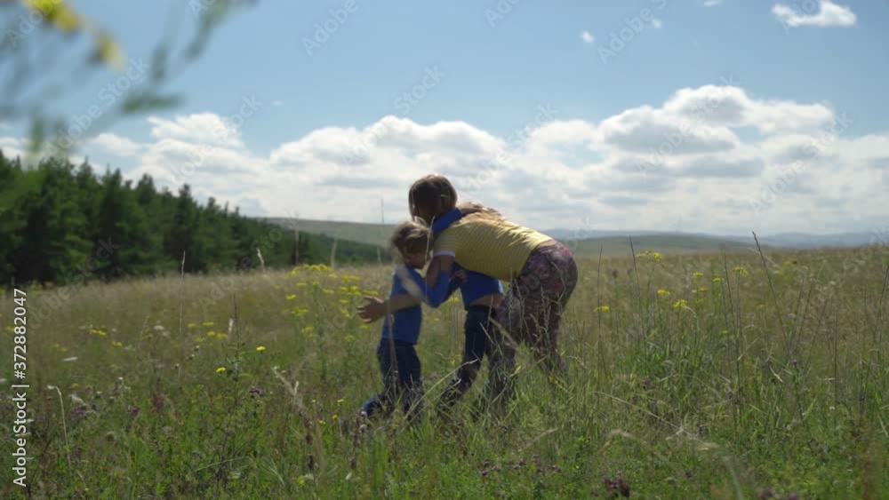 Mom and children are walking in the field. Wildflowers, summer. Mom and children are walking in the field. Wildflowers, summer.