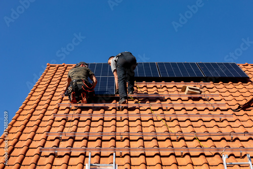 Wallpaper Mural  Workers installing solar electric panels on a house roof in  Ochojno. Poland Torontodigital.ca