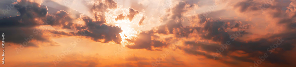 Colorful sunset panorama against dramatic clouds background