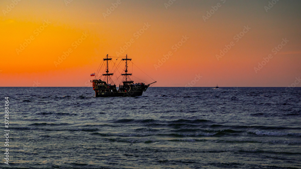 big pirate boat in the sunset sea