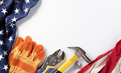 Happy Labor day concept. American flag with different construction tools on white background, with copy space for text.
