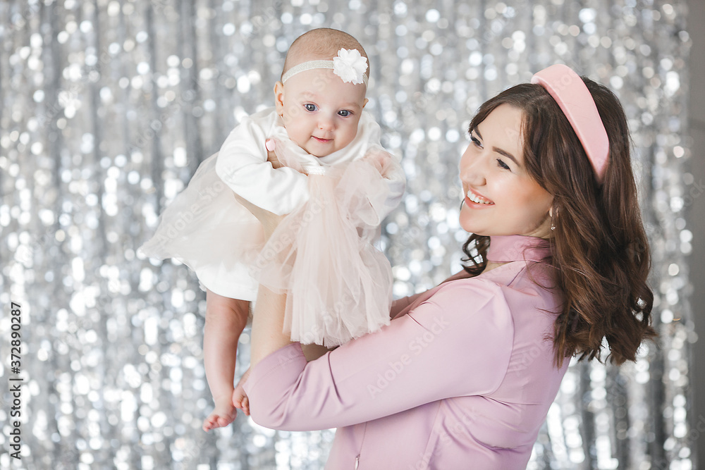Attractive young mother holding her cute little baby girl. Attractive young mother holding her cute little baby girl.