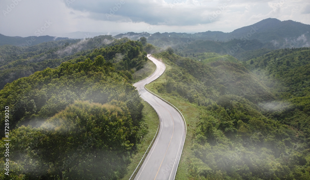 Nan, Thailand. Aerial view of Beautiful sky road over top of mountains with green jungle. Road trip on curve road in mountain.