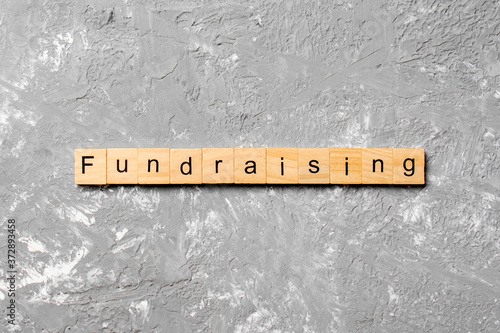 fundraising word written on wood block. fundraising text on table, concept