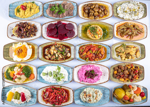 Traditional Turkish and Greek dinner meze table. Turkish Cuisine Cold Appetizers (appetizers with olive oil). Turkish appetizers in colorful plates. yogurt and various boiled herbs. photo