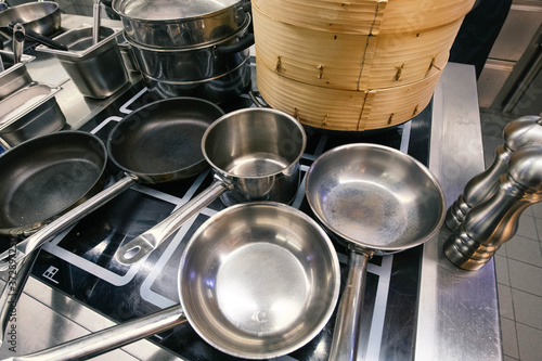 Pots, pans and dim sum baskets waiting in a kitchen to be used.